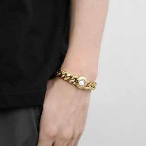 Detailed view of an 11mm gold Cuban link bracelet with a crystal skull buckle on wrist