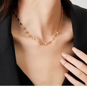 Detail of 18K gold plated stainless steel necklace with shiny discs worn by a model