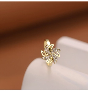 Detailed view of rotating gold windmill ring with sparkling white zircon inlay