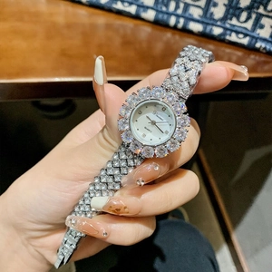 Luxury women's quartz watch with full crystal inlay and silver steel strap on wrist