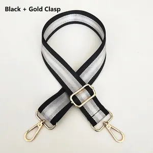 Detail of adjustable black and silver striped nylon bag strap with gold metal hooks