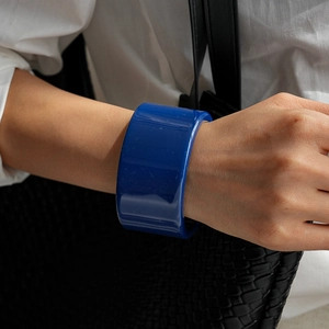 Détail d'un large bracelet en résine bleue avec surface concave lisse sur un mannequin