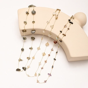 Détail de colliers bohèmes dorés avec cristaux naturels irréguliers et labradorite
