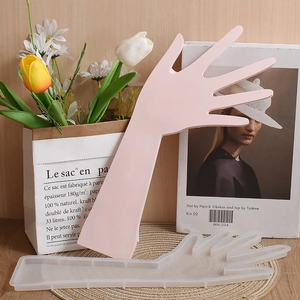 Vista dettagliata dello stampo in silicone a mano e supporto in resina rosa per gioielli