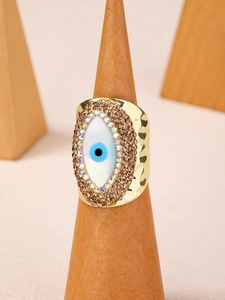 Detail of 14K gold-plated Evil Eye ring with shell inlay and brown sparkling rhinestones