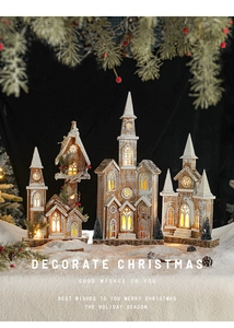 Close-up of lighted wooden Christmas house ornaments with warm glow on snow