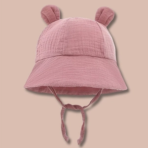 Detail of baby sun hat with cute ears and adjustable strap in breathable pink cotton