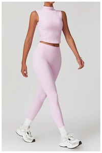 Seitenansicht einer Frau im hellrosa Yoga-Set mit ärmellosem Crop-Top und Sport-Leggings