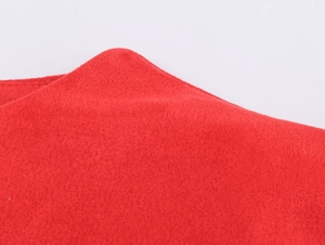 Gros plan sur la texture du tissu en daim rouge doux de la robe courte moulante