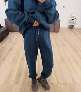 Detail of dark blue zip-up hoodie set with ribbed cuffs and elastic waist pants