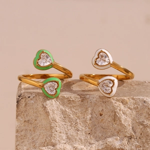 Detail of 18K gold plated rings with green and white enamel hearts and cubic zirconia