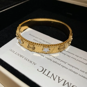 Close-up of golden stainless steel flower bracelet with white mother of pearl inlay detail