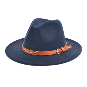 Detail of navy blue wool fedora hat with studded brown leather band and metal buckle