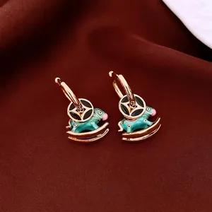 18K gold plated rocking horse earrings with black and blue enamel charms on velvet