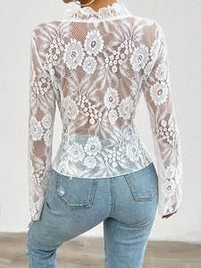 Detailed back view of white lace long-sleeved top with intricate floral hollow patterns