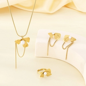 Golden bow jewelry set with pearls and tassels including necklace earrings and ring