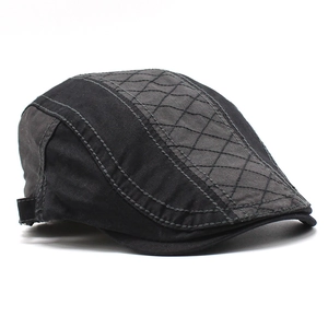 Detail view of cotton beret featuring grey quilted panel and precise stitching