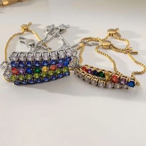 Detail of adjustable rainbow gemstone bracelet with gold and silver pull-clasp chains