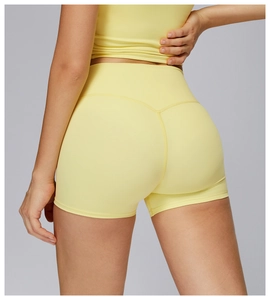 Dettaglio degli shorts da yoga gialli a vita alta con tessuto senza cuciture e fit
