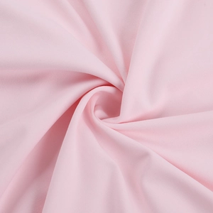 Detailed macro shot of soft pink jersey fabric with elegant central twist and elastic texture