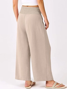 Détail de la taille haute élastique et de la texture verticale du pantalon large beige