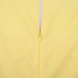 Détail du zip invisible sur le tissu jaune scintillant d'une robe à manches longues