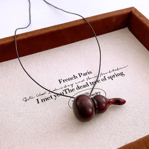 Collier vintage avec pendentif gourde en bois rouge foncé et cordon noir pour femme