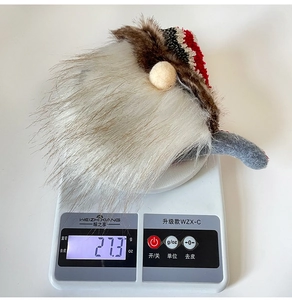 Detailed view showing the 27.3g weight of a Christmas gnome plush with a knitted hat