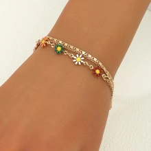 Close-up of double-layered floral bracelet with daisy charms on a model's wrist