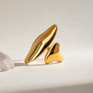 Irregular sculptural gold stainless steel open ring on a natural stone background