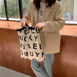 Detailaufnahme der großen Canvas-Tragetasche mit schwarzem Buchstabendruck und Smiley-Logo