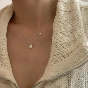 Minimalist 925 sterling silver shell and pearl pendant necklace worn on a female model