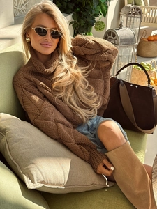 Women's brown high neck argyle knit sweater paired with denim shorts and long boots