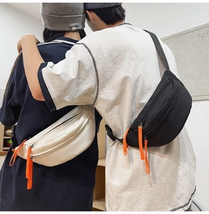 Detail of waterproof crossbody bag with dual main pockets and orange zipper puller cord