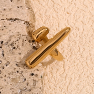 Detailed close-up of an 18K gold-plated bar ring set on a natural beige stone