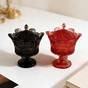 Macro detail of vintage crown-style glass storage jars in elegant black and ruby red finish