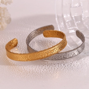 Detail of 18K gold and silver plated open bangles with unique hammered texture design