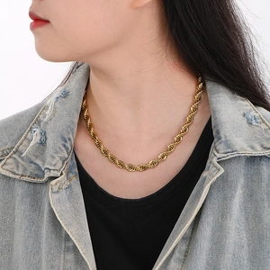 Close-up of golden stainless steel twist rope chain necklace worn by a model