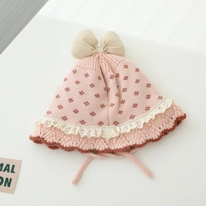 Detail der Baby-Strickmütze mit zarter Spitzenkante und braunem Wellenrand