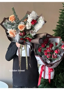 Detail view of a festive Christmas bouquet with red roses, pine cones and cotton textures