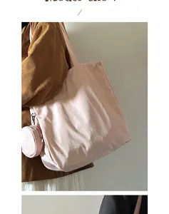 Pink nylon tote bag with matching detachable round coin purse shown on female model