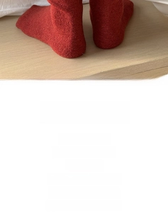 Detail of red wool knit socks featuring elegant bow ties for a cozy autumn look
