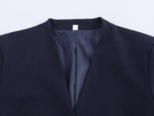 Detail shot of navy blue blazer neckline showing premium fabric texture and satin lining