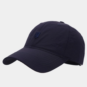 Detail of navy blue quick-dry baseball cap with embroidered shield logo and neat stitching