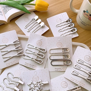 Silver Y2K metal hair clips set with star and heart shapes on a decorative tray