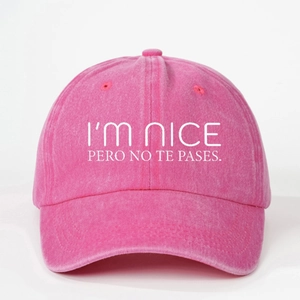 Pink washed cotton baseball cap with white slogan I'M NICE PERO NO TE PASES embroidery
