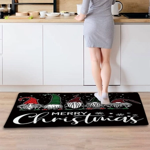 Detail of Christmas gnomes on black flannel kitchen mat with Merry Christmas text