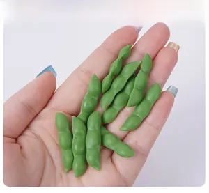 Close-up of a mini realistic green PVC soybean pod model held in hand for scale