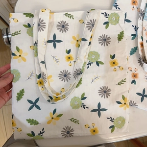 Detail of floral printed canvas tote bag showing the lemon yellow and mint green flower pattern