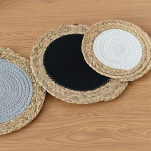 Macro view of round woven heat-resistant table mats in grey, black, and white tones